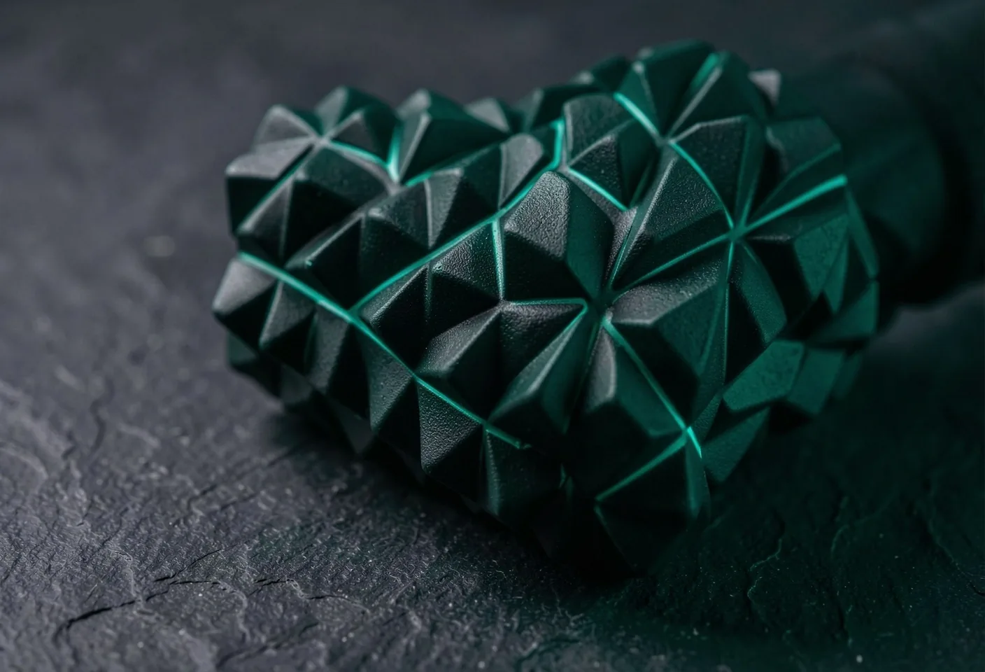 Textured foam roller with emerald rim lighting on a dark surface